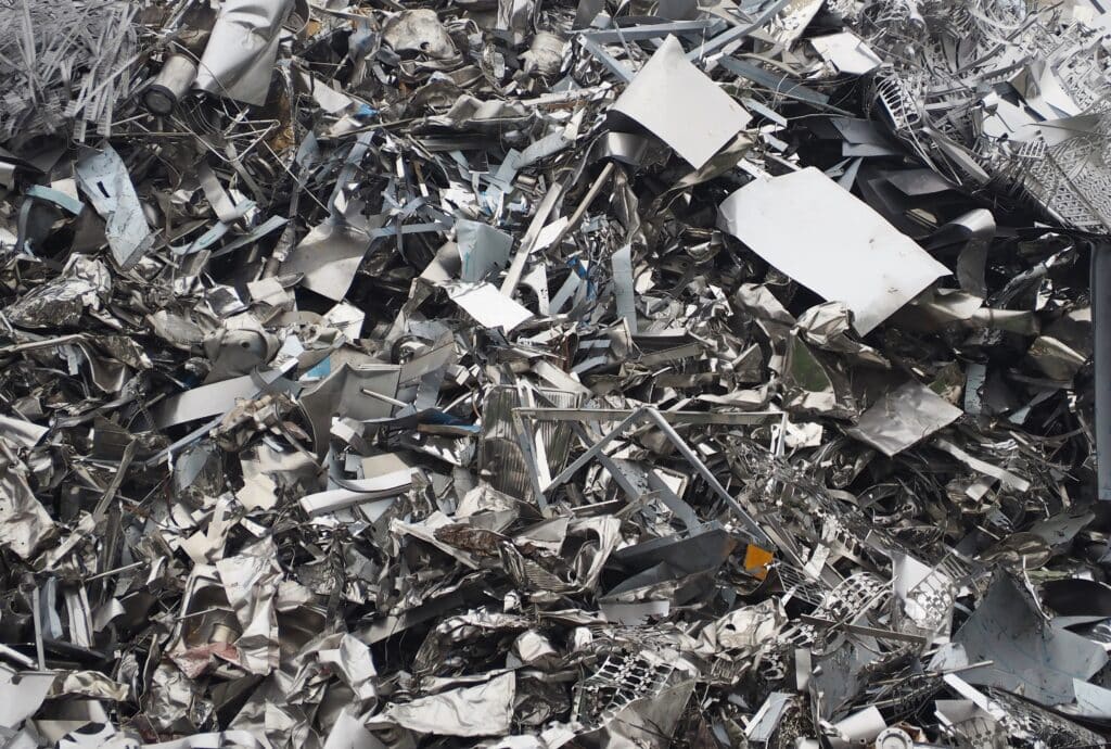 Ferraille d'aluminium et acier : gros plan sur recyclage Gros plan sur une montagne de ferraille d'aluminium et d'acier inoxydable froissé, avec des morceaux blancs visibles.
